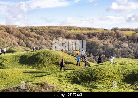 Menschen, die am Sonntagmorgen die Wintersonne am Cotswold-Aussichtspunkt von Haresfield Beacon, Gloucestershire, Großbritannien, genießen Stockfoto