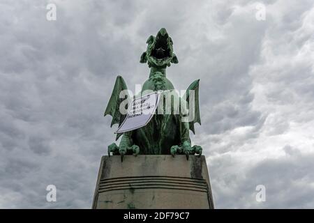 Drachenstatue an der Drachenbrücke in Ljubljana mit einem Schild gegen Sloweniens Ministerpräsidenten Janez Jansa, Slowenien Stockfoto