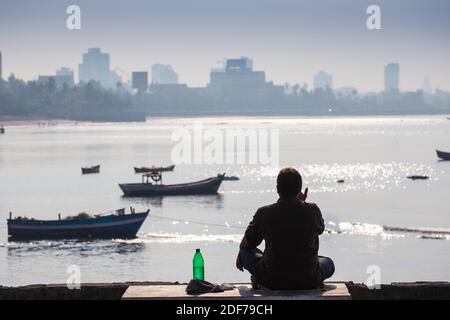 Indien, Maharashtra, Mumbai, Chowpatty, man sitzt Lon Waterfront Stockfoto