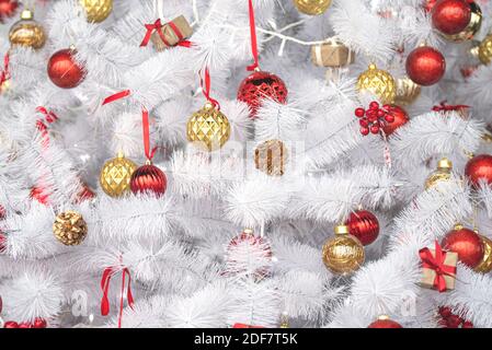 Weißer oder silberner Weihnachtsbaum mit roten, goldenen Spielzeugen, Neujahrskomposition Stockfoto