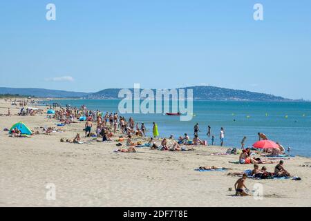 Frankreich, Herault, Marseillan-Plage, Vacationerson ein Strand mit dem Mont Saint-Clair de Sete im Hintergrund Stockfoto