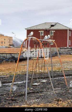 Alte Schaukel auf dem Kinderspielplatz in Pyramiden, verlassene sowjetische Kohlensiedlung auf Spitzbergen Stockfoto