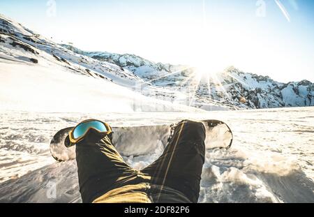 Snowboarder beim Sonnenuntergang auf Relax Moment in den europäischen alpen Skigebiet - Wintersport Konzept mit Kerl und Snowboard Auf der Bergspitze bereit zu reiten Stockfoto