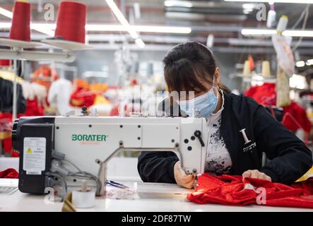 Peking, Chinas Provinz Yunnan. November 2020. Eine Frau arbeitet in einer Werkstatt eines Umzugsortes zur Armutsbekämpfung im Bezirk Zhenxiong, südwestlich der Provinz Yunnan, 13. November 2020. Quelle: Wang Guansen/Xinhua/Alamy Live News Stockfoto