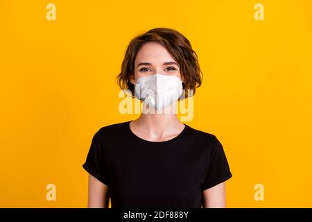 Portrait von schönen braunen Haaren Mädchen tragen Gesichtsbehandlung medizinische Maske Baumwolle T-Shirt isoliert gelbe Farbe Hintergrund Stockfoto