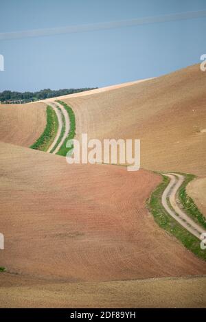 Kurvenreiche Straße durch trockene Landschaft mit leeren Feldern in Andalusien, Spanien Stockfoto