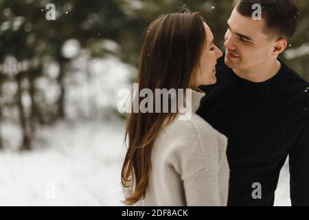Junge glückliches Paar in der Liebe im Winterwald mit Kopierraum. Liebe, Beziehung, Winterurlaub. Winter paar Foto-Ideen Stockfoto