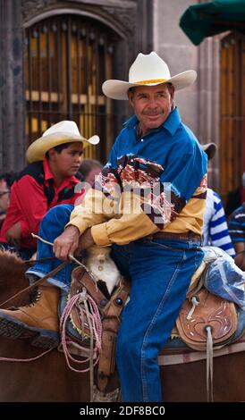 CABALLEROS oder MEXIKANISCHE COWBOYS fahren in die Stadt, um die jährliche PARADE DES UNABHÄNGIGKEITSTAGES im September zu beginnen - SAN MIGUEL DE ALLENDE, MEXIKO Stockfoto