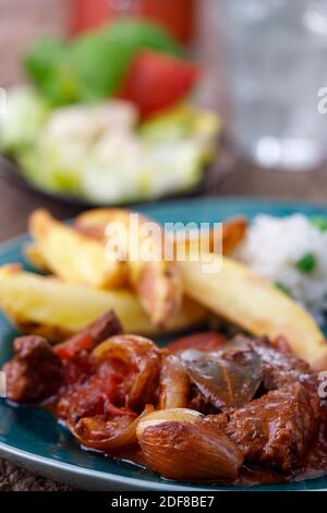 griechischer Stifado-Fleischeintopf mit Pommes frites Stockfoto