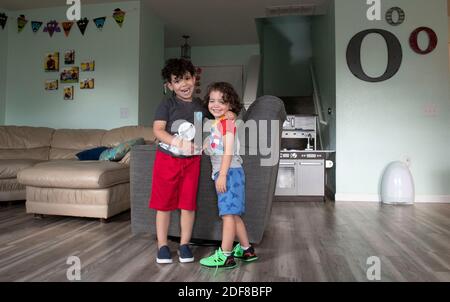 Kafry (6) Overton in roten Shorts, mit seinem Bruder Saben (4) in blauen Shorts im Wohnzimmer ihres Hauses in Süd-Austin. Stockfoto