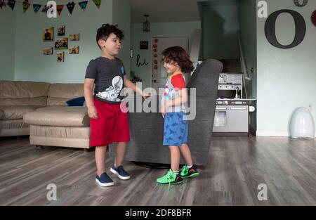 Kafry (6) Overton in roten Shorts, mit seinem Bruder Saben (4) in blauen Shorts im Wohnzimmer ihres Hauses in Süd-Austin. Stockfoto