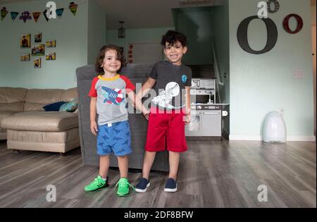 Kafry (6) Overton in roten Shorts, mit seinem Bruder Saben (4) in blauen Shorts im Wohnzimmer ihres Hauses in Süd-Austin. Stockfoto