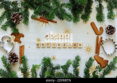 Happy Marry Weihnachten Inschrift. Blick von oben. Layout des neuen Jahres. Neujahrsschrift zwischen Tannen und Keksen Stockfoto