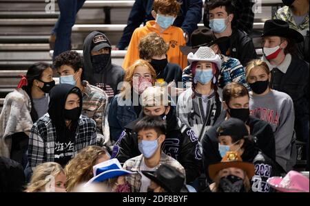 Chilly Cedar Ridge Schüler tragen Masken und huddle in den Ständen bei einem High School Fußballspiel im Dragon Stadium in Round Rock, Texas an einem kalten und windigen Freitagabend während der COVID Pandemie. Die Studenten distanzierten sich nicht sozial. Stockfoto