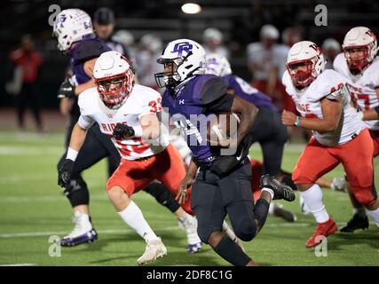 Coy Rugely (14) von Cedar Ridge wird von Reed Runkel (33) verfolgt, da Cedar Park Vista Ridge (weiß) einen entscheidenden Sieg über Round Rock Cedar Ridge (blau) in einem District 25 6A High School Fußballspiel im Dragon Stadium in Round Rock erzielt. Vista Ridge gewann, 38-24. Stockfoto