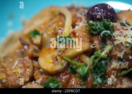 Typisch italienisches Gericht: Eine großzügige Portion Spaghetti mit Pilzsauce auf einem blauen Teller Stockfoto