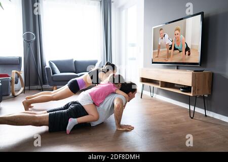 Familie tun Fitness-Übung beim Fernsehen Stockfoto