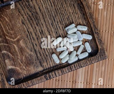 Nahaufnahme von Ester-c Tabletten auf einem hölzernen Hintergrund. Biologisch aktive Ergänzungen topview Foto. Stockfoto