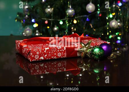 Weihnachtsgeschenk in hellem Papier verpackt und liegt auf dem Tabelle Stockfoto