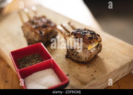 Nahaufnahme von gegrillten Rippchen und Salz-Pfeffer-Behältern Auf Holzbrett Stockfoto