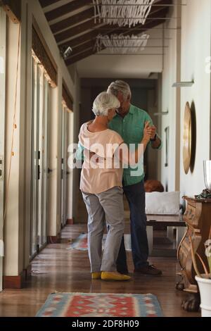Rückansicht des älteren kaukasischen Paares, das zu Hause zusammen tanzt Stockfoto