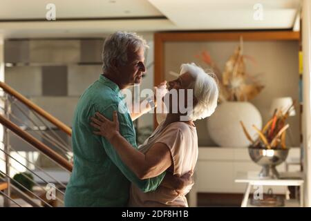 Glückliches älteres kaukasisches Paar, das zu Hause zusammen tanzt Stockfoto