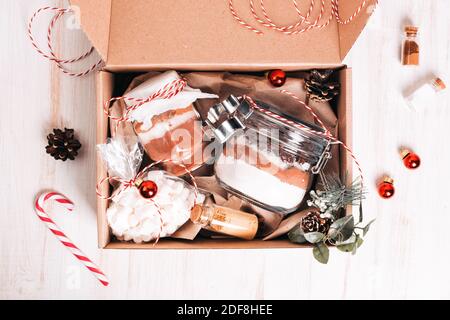 Weihnachts-Geschenkbox mit Plätzchen-Mix und Schokoladengetränk im Glas auf dunklem Holztisch. Schichten von Mehl, Kakaopulver, Zucker. Zutaten für Ingwer Stockfoto