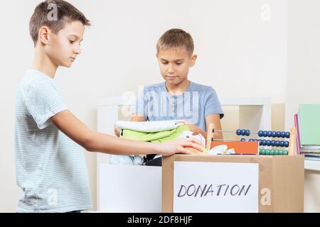 Kinder Freiwillige Sortieren Spielzeug, Kleidung, Bücher, Spenden Waren in Spenden Wohltätigkeitskisten Stockfoto