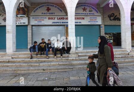 Bethlehem, Westjordanland. Dezember 2020. Palästinenser passieren am Donnerstag, den 3. Dezember 2020, auf dem Manger Square in Bethlehem, Westjordanland, verschüttete Souvenirläden. Der Bürgermeister von Bethlehem Anton Salman sagte, dass die biblische Stadt wirtschaftlich leidet, da der Tourismus die Haupteinnahmequelle ist, die am 5. März mit dem Ausbruch von COVID-19 vollständig zum Stillstand kam. Mehr als 1.5 Millionen Menschen besuchten die Geburtskirche im Jahr 2019. Foto von Debbie Hill/UPI Kredit: UPI/Alamy Live Nachrichten Stockfoto