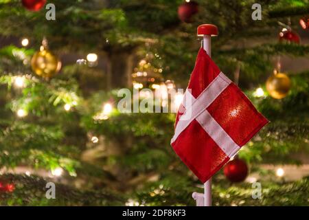 Schöner Weihnachtsbaum mit dänischer Flagge, skandinavischen Kerzenleuchter, Ornamenten und Lichtern, Weihnachtsschmuck und Hintergrund Stockfoto