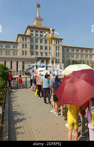 Besucher warten an einem heißen und sonnigen Tag darauf, das kürzlich umgestaltete nationale Militärmuseum im zentralen Westen Pekings, China, zu betreten Stockfoto