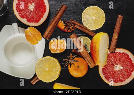 Anis Zimt und Zitrus auf schwarzem Hintergrund. Weihnachtsdüfte. Apfel, Zimt und Mandarinen. Geschnittenes Obst. Traditionen der Welt. Zimtstange und l Stockfoto