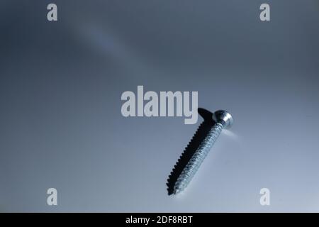 Eine Schraube und ihr Schatten auf weißem Hintergrund Stockfoto