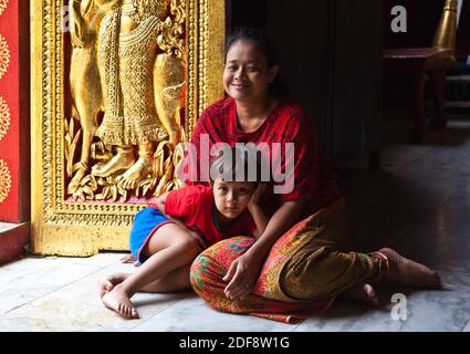 Thailändische Mutter und Kind in der buddhistischen WAT XIENG THONG (Tempel der goldenen Stadt), erbaut im Jahre 1560 - LUANG RACHENTUPFER, LAOS Stockfoto