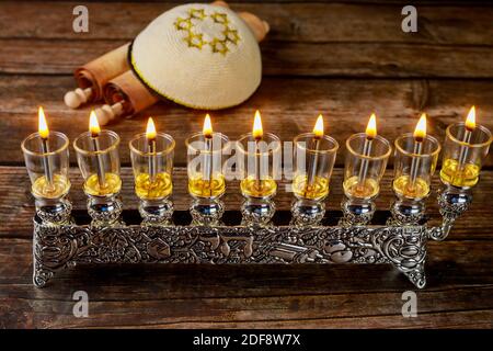 Vintage Menorah mit brennenden Ölkerzen und Kippah mit Totah für Chanukka. Jüdischer Feiertag. Stockfoto