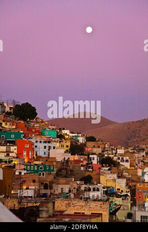 Der VOLLMOND erhebt sich über den bunten Häusern auf dem Hügel der Kulturstadt GUANAJUATO in ZENTRALMEXIKO Stockfoto