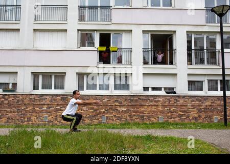 Ein Sporttrainer gibt einen Turnkurs für die Bewohner eines Arbeiterviertels in Suresnes, Vororte von Paris, Frankreich am 3. April 2020 in unter Sperre für einige Wochen. Zwei Bewohner und Mitglieder des Vereins Collectif Solidaire des Chenes Ismael Ichaoui und Smail Belkacem beschlossen, drei Mal in der Woche Sportunterricht für Menschen auf ihren Balkonen zu geben. Foto von Raphael Lafargue/ABACAPRESS.COM Stockfoto