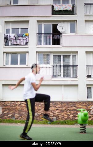 Ein Sporttrainer gibt einen Turnkurs für die Bewohner eines Arbeiterviertels in Suresnes, Vororte von Paris, Frankreich am 3. April 2020 in unter Sperre für einige Wochen. Zwei Bewohner und Mitglieder des Vereins Collectif Solidaire des Chenes Ismael Ichaoui und Smail Belkacem beschlossen, drei Mal in der Woche Sportunterricht für Menschen auf ihren Balkonen zu geben. Foto von Raphael Lafargue/ABACAPRESS.COM Stockfoto