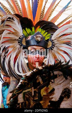 AZTEKEN-TÄNZER treten während des CERVANTINO FESTIVALS - GUANAJUATO, MEXIKO in einem traditionellen Krieger-FEDERKOSTÜM auf Stockfoto