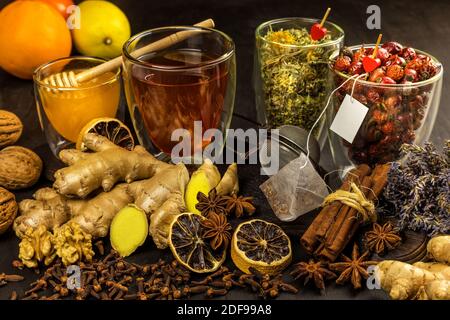 Ingwertee in einer Tasse auf schwarzem Holzhintergrund. Zimt und Sternanis mit Nelken. Behandlung von Grippe und Erkältungen. Kräutertee. Stockfoto