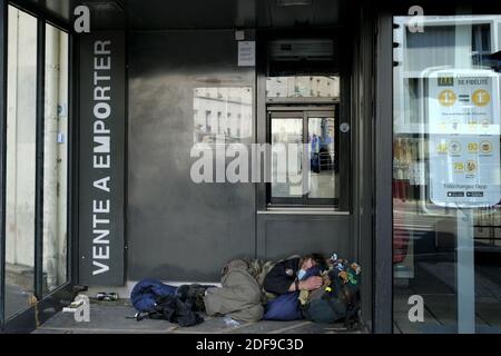 Ein obdachloser Mann schläft auf dem Eingang von mac mac McdonaldâÂ € Â™s in Paris während der Coronavirus-Krankheit (COVID-19). Nach der Ankündigung durch den französischen Präsidenten Emmanuel Macron der strengen Hauseinsperrregeln der Französisch aufgrund eines Ausbruchs der Coronavirus-Pandemie (COVID-19) am 18. März 2020 in Paris, Frankreich. Die Franzosen werden zu Hause bleiben müssen, Frankreich hat alle Schulen, Theater, Kinos und eine Reihe von Geschäften geschlossen, wobei nur diejenigen, die Lebensmittel und andere wichtige Dinge verkaufen, offen bleiben dürfen. Verbot aller Ausflüge, die nicht unbedingt notwendig sind, um das CO einzudämmen Stockfoto