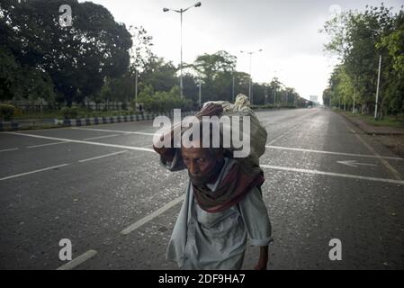 Ein alter Mann trägt Waren auf einer verlassenen Straße in Kalkutta während der 2. Phase der Sperre in Indien wegen covid 19 Pandemie. Kolkata, Westbengalen, Indien, 28. April 2020. Arindam Mukherjee Stockfoto