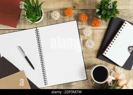 Notizbuch, Tagebuch und Kaffee mit Blumendekoration auf Holzhintergrund. Rustikale Nostalgie flach legen. Stockfoto