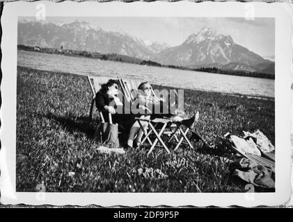 Historisches Foto: Paar sonnenbaden, in der Sonne liegen und sich am Hopfensee in Hopfen am See bräunen, Bayern, 1950. Fortpflanzung in Marktoberdorf, Deutschland, 26. Oktober 2020. © Peter Schatz / Alamy Stock Photos Stockfoto