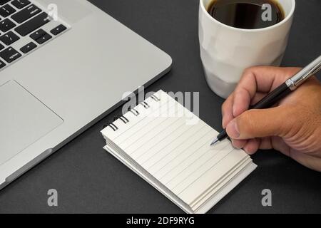 Hand hält einen Stift und schreiben auf Notebook. Textkopierbereich. Stockfoto