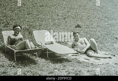 Historisches Foto: Paar mit Sonnenliegen1963 am Hopfensee in Hopfen am See, Bayern, Deutschland. Fortpflanzung in Marktoberdorf, Deutschland, 26. Oktober 2020. © Peter Schatz / Alamy Stock Photos Stockfoto