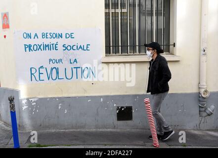 Eine Person, die eine Schutzmaske trägt, geht an der Botschaft "Wir brauchen soziale Nähe für die Revolution" vorbei, die am 12. Mai 2020 in Paris, Frankreich, am zweiten Tag der Definierung in Frankreich aufgrund der Ausbreitung des Covid-19-Virus geschrieben wurde. Foto von Alain Apaydin/ABACAPRESS.COM Stockfoto