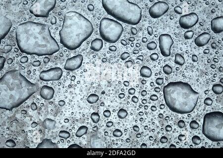 Abstrakte Ansicht mit silberner Glitzer-Metalloberfläche mit vielen Reliefs Wasser fällt als Hintergrund Vorderansicht Nahaufnahme Stockfoto