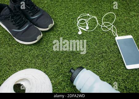 Sport Set Junge oder Mädchen, die gerne laufen. Telefon, Kopfhörer, Schuhe, Wasserflasche und Chips zum Laufen. Isolierte Stelle für Text Stockfoto