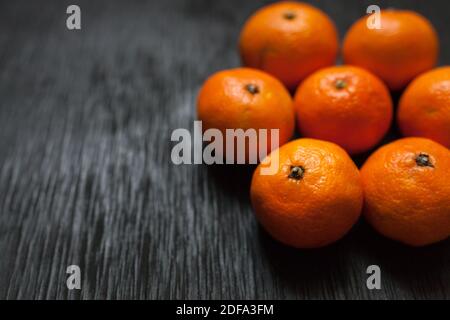 Mandarinen auf schwarzem Hintergrund. Viel frisches Obst - Mandarinen. Hochwertige Fotos Stockfoto